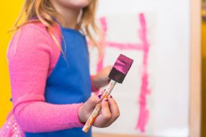 Une petite fille faisant de la peinture.