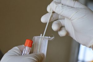 Un expert de laboratoire passe un test d'écouvillonnage covid-19.